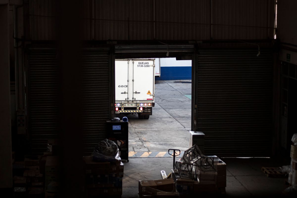 A truck leaving a warehouse loading dock in the evening